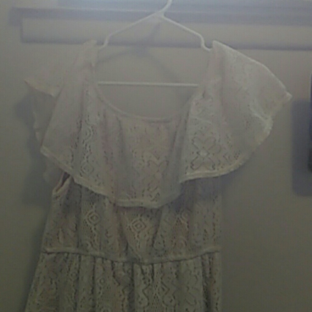 Off the shoulder cream dress with lace on top.